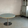 Tavolo tondo diametro 120 cm. Struttura in ferro e piano d'appoggio in resina con inserti in rilievo.